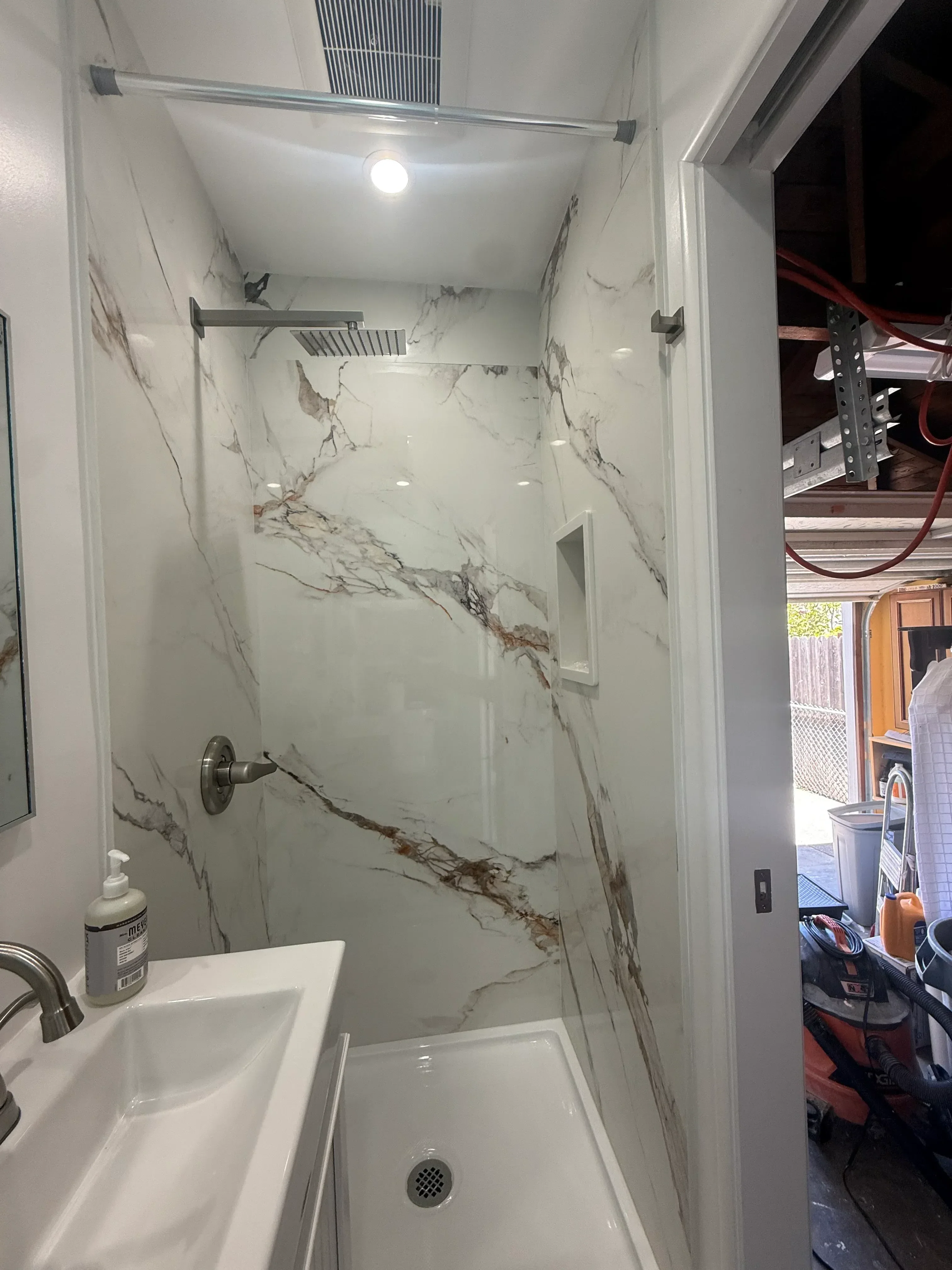 Marble tile bathroom with veined walls, recessed lighting, and chrome fixtures
