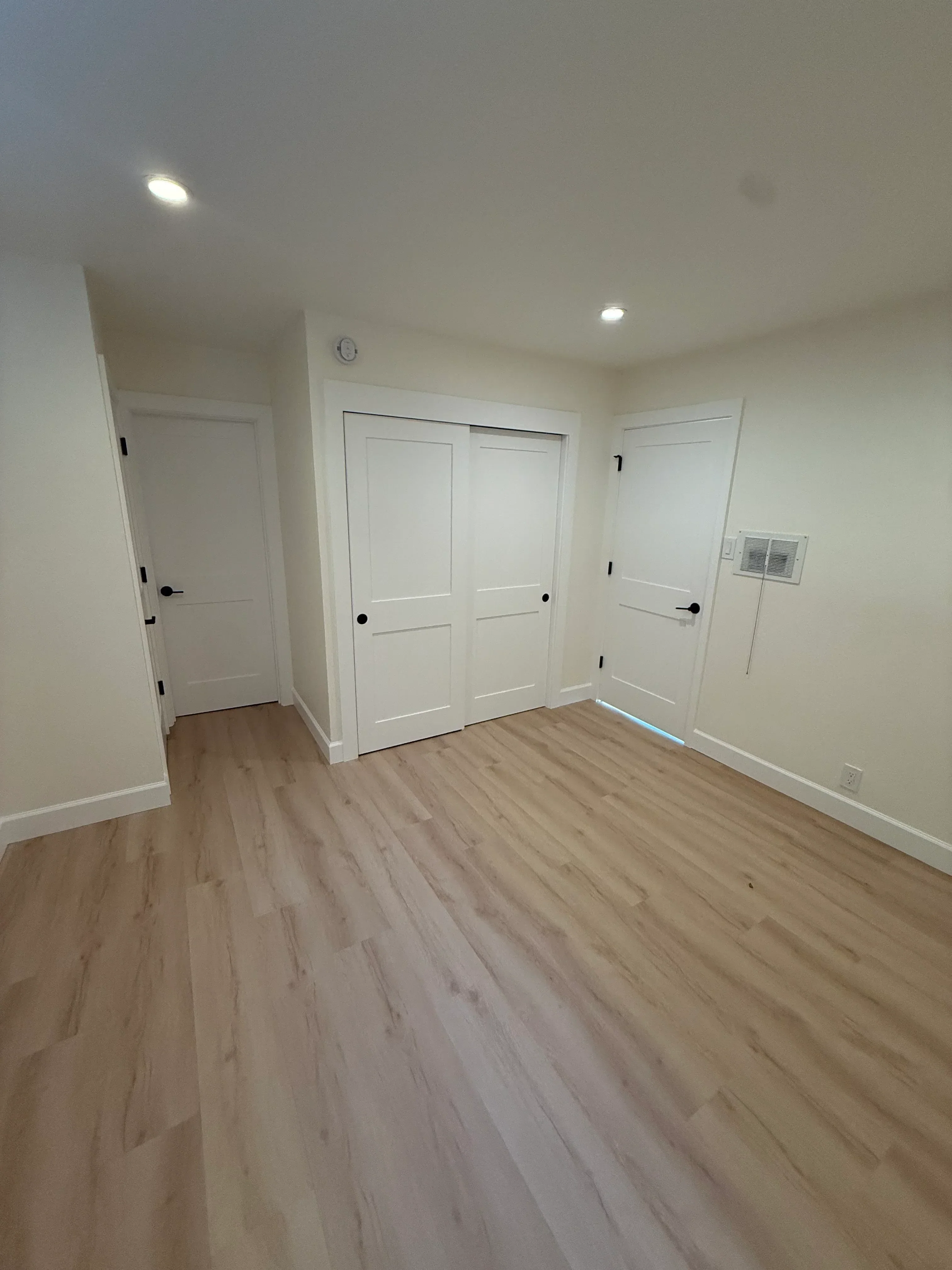 Drywall, recessed lighting, and vinyl plank flooring in residential interior space